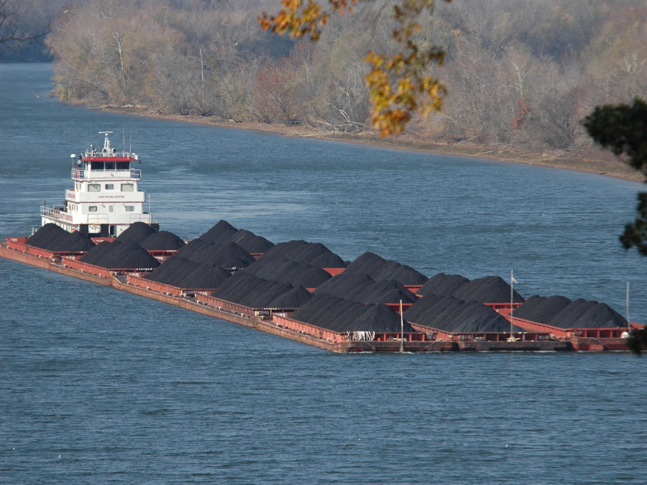 A Marquette River boat towing a barge full of coal